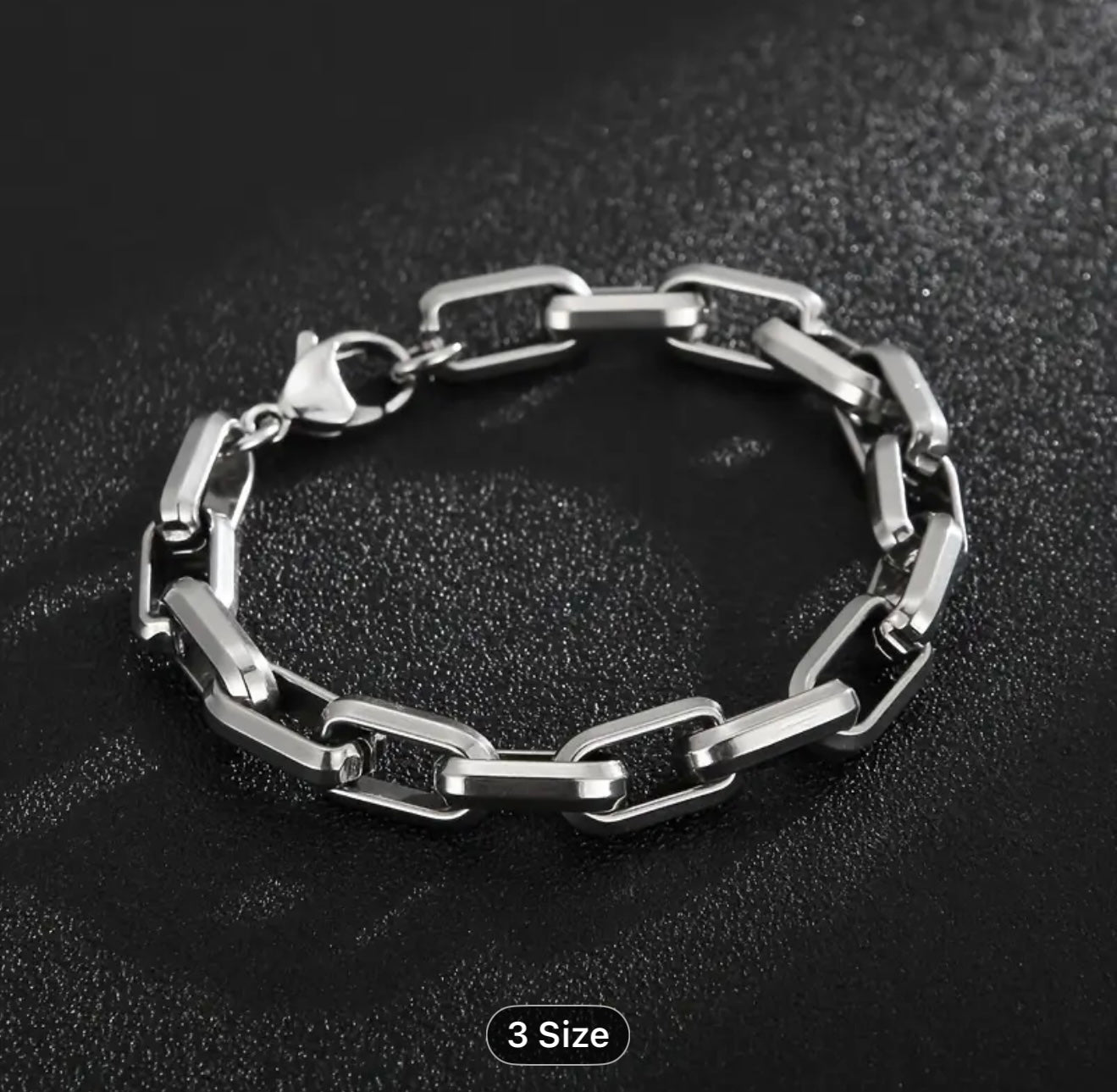 Silver chain bracelet on a black textured background