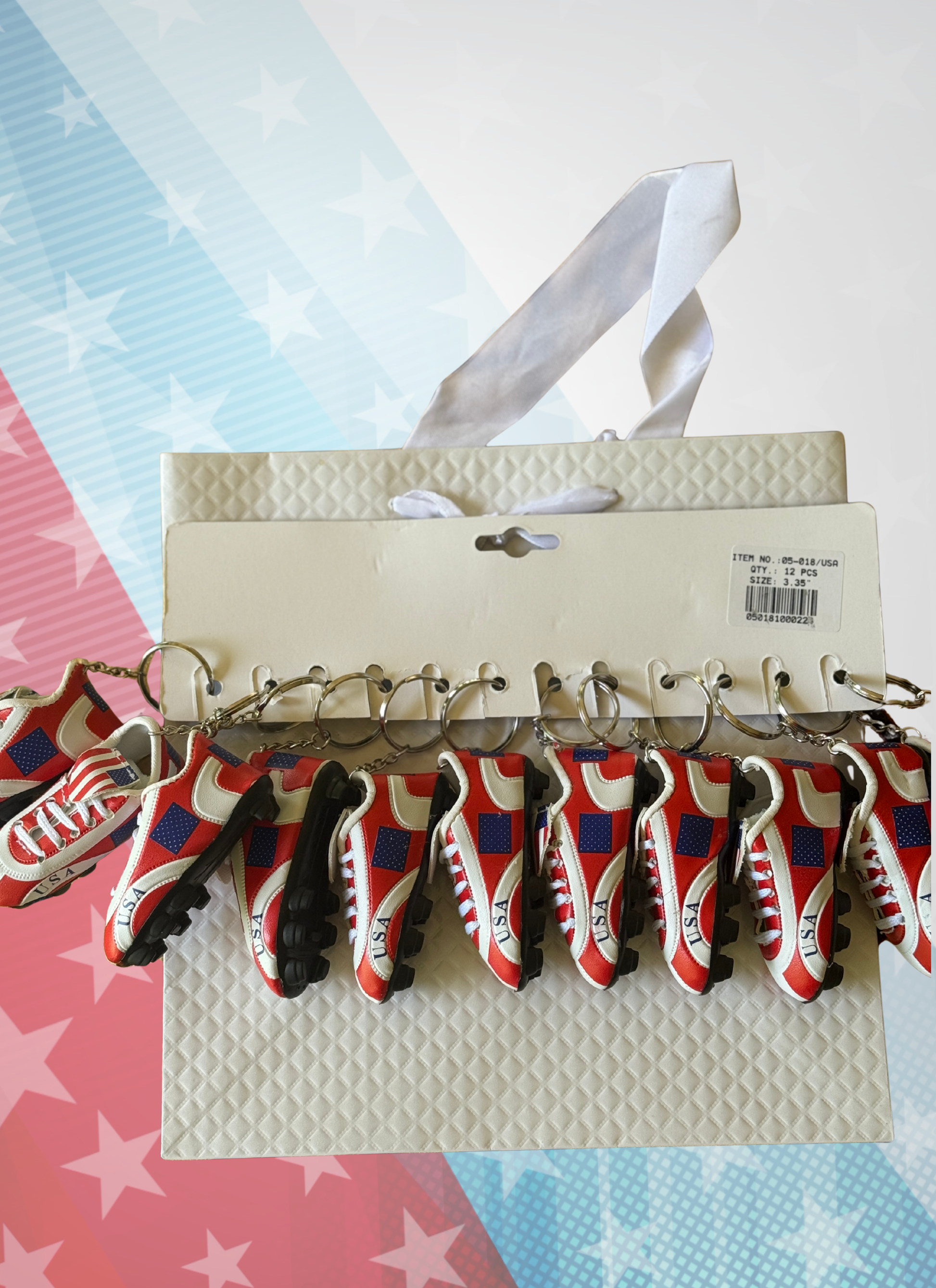 Set of keychains shaped like red, white, and blue shoes on a cardboard backing with a star-patterned background.
